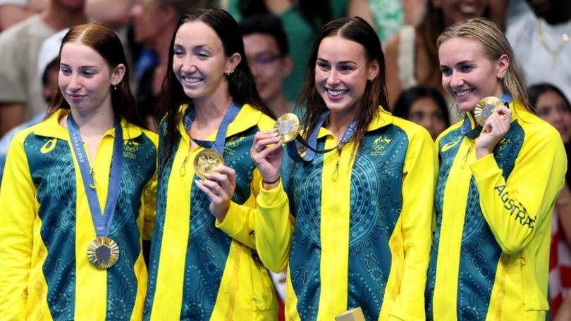 Mollie O’Callaghan, Lani Pallister, Brianna Throssell and Ariarne Titmus celebrate on the podium with their gold medals.