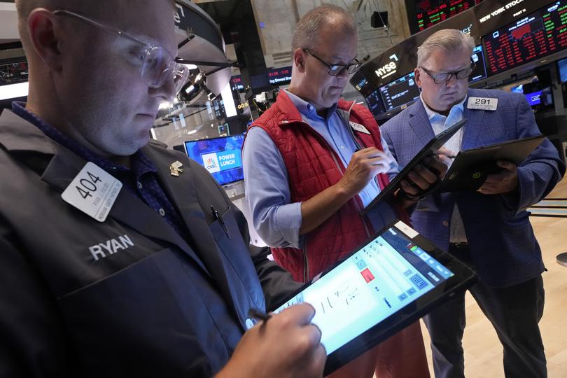 A trio of traders work on the floor of the New York Stock Exchange on Friday, August 2.