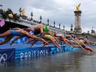 Triathletes dive into the River Seine for the women’s triathlon.