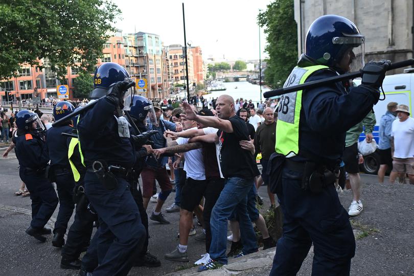 Police officers face off with protesters during the 'Enough is Enough' demonstration called by far-right activists in Bristol on August 3, 2024. Far-right protesters clashed with British police during tense rallies as unrest linked to disinformation about a mass stabbing that killed three young girls spread across the UK. (Photo by JUSTIN TALLIS / AFP)