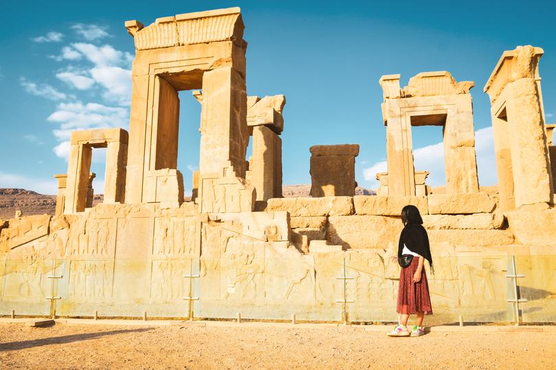 Persepolis, Iran - 8th june, 2022: A tourist walks in Persepolis, an ancient persian city in south Iran. 