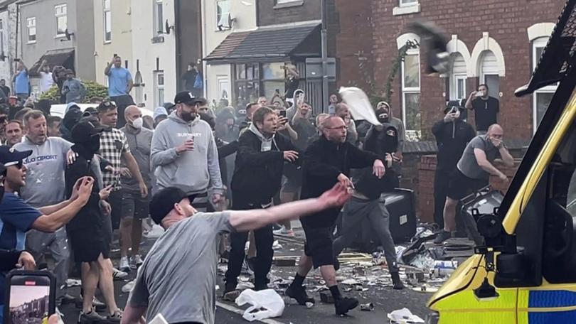 An unruly crowd clash with police in Southport UK