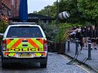 A rioter throws a beer keg at a police car in Bristol during the 'Enough is Enough' demonstration held in reaction to the fatal stabbings in Southport.