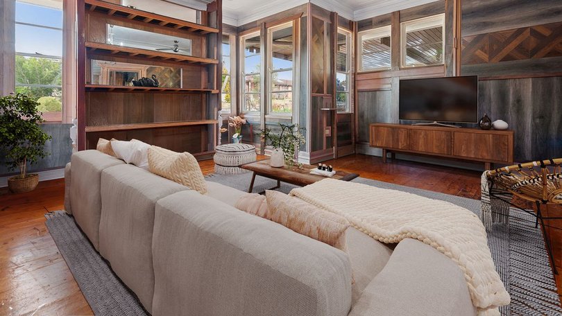 The living room features timber flooring as decorative wall panls.