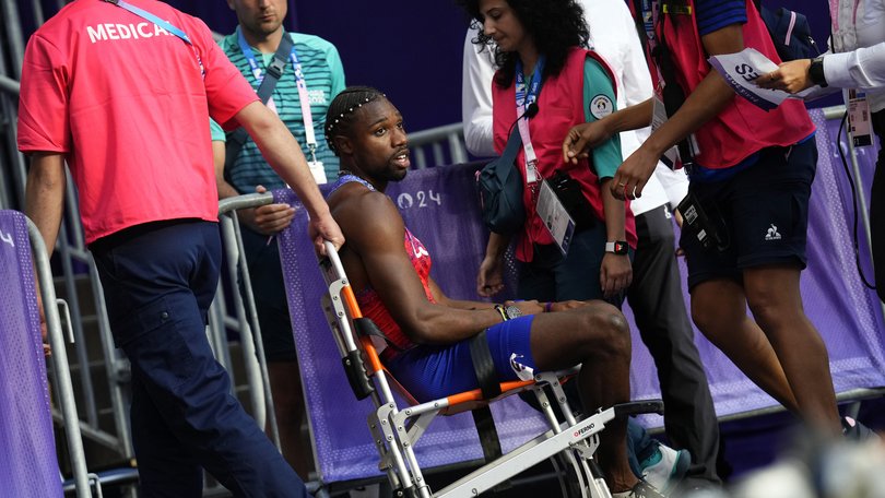 Noah Lyles is taken away in a wheelchair.