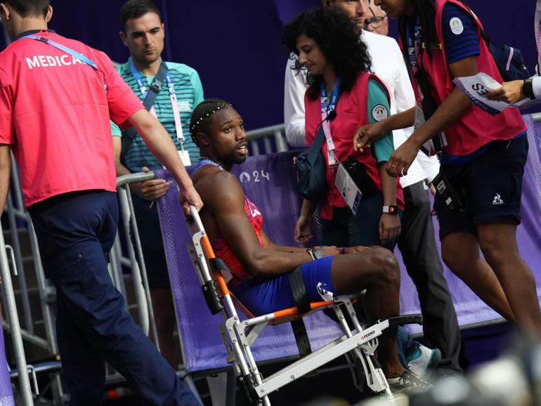 Noah Lyles is taken away in a wheelchair.