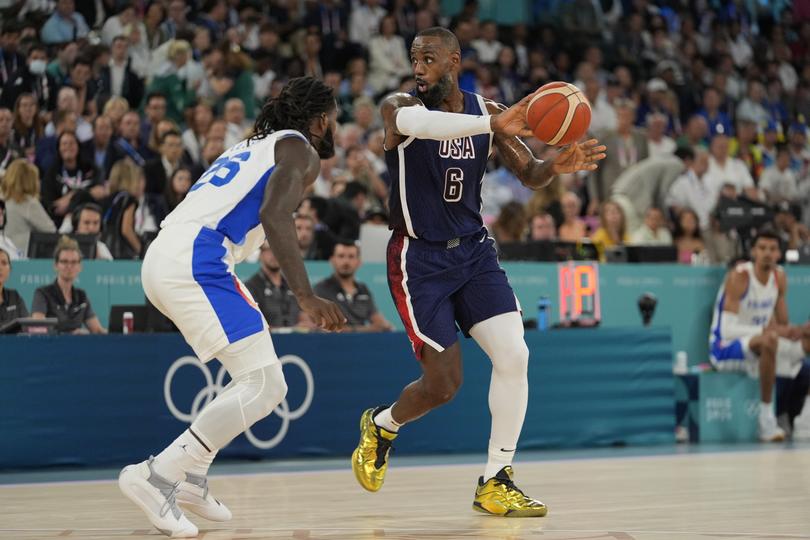 United States' LeBron James (6) passes around Mathias Lessort (26), of France during a men's gold medal basketball game at Bercy Arena at the 2024 Summer Olympics, Saturday, Aug. 10, 2024, in Paris, France. (AP Photo/Rebecca Blackwell)