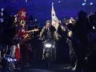 Tom Cruise rides on a Motorbike with the IOC Flag.