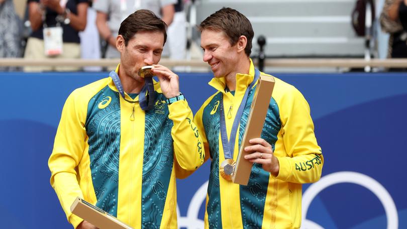 Gold medallists Matthew Ebden and John Peers of Team Australia celebrate on the podium during the Tennis Men's Doubles medal ceremony.