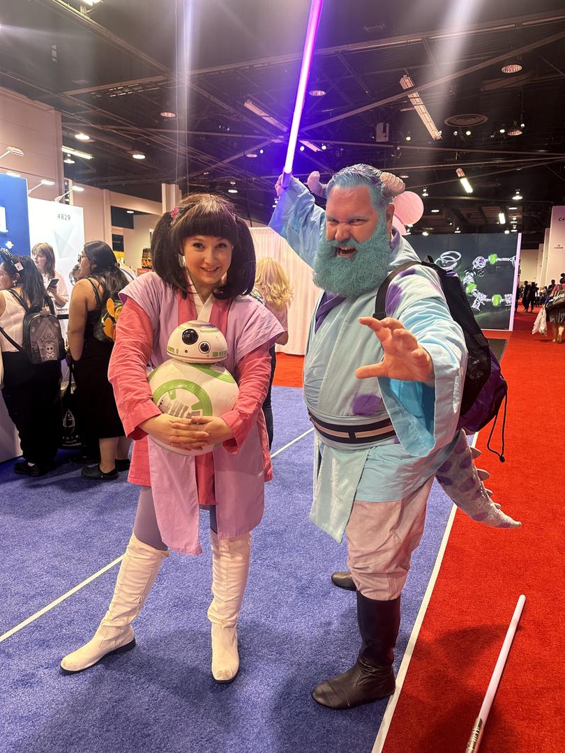 Two cosplayers at D23, dressed as a cross between Jedi knights and Monsters Inc's Boo and Sully.