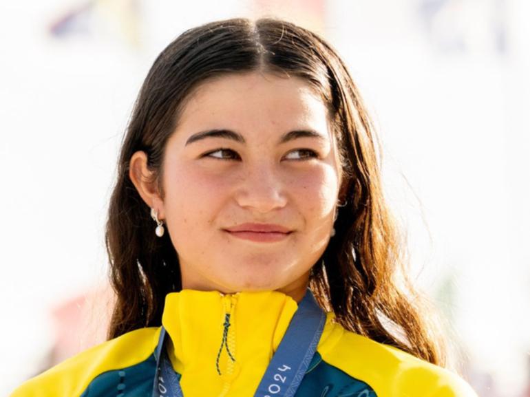 Australian gold medallist Arisa Trew gave up her business class seat on the way home to sit with her friends.