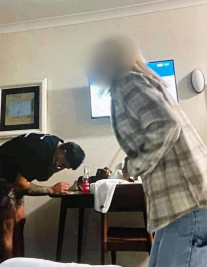 The photo appears to show Mitchell leaning over a table with a white substance.