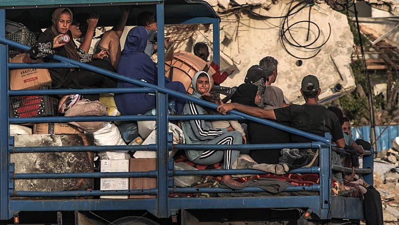 Displaced Palestinians leave with their belongings