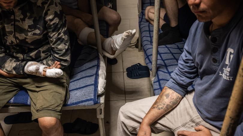 Captured Russian soldiers and border guards sit in a cell in a Ukrainian prison in northeastern Ukraine. 