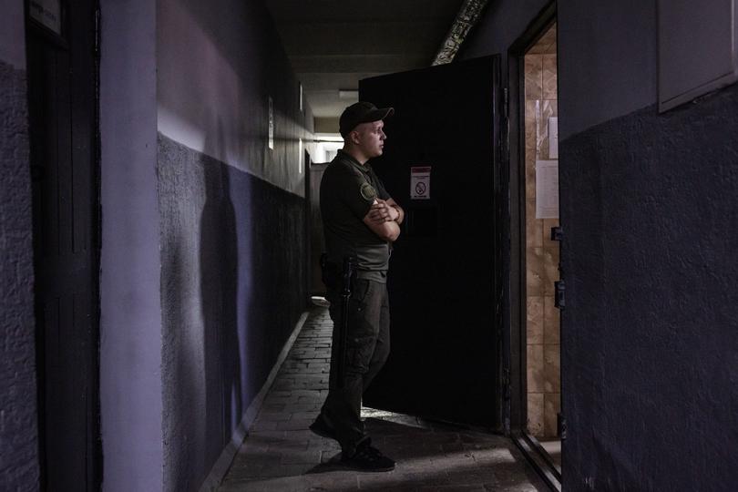 A prison guard looks into a cell. 