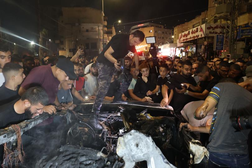 Palestinian emergency services at the scene where at least two people were killed after an Israeli airstrike hit a vehicle in the West Bank city of Jenin.