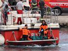 Firefighter teams, Vigili del Fuoco, arrive in Porticello harbor with a recovered body near Palermo.