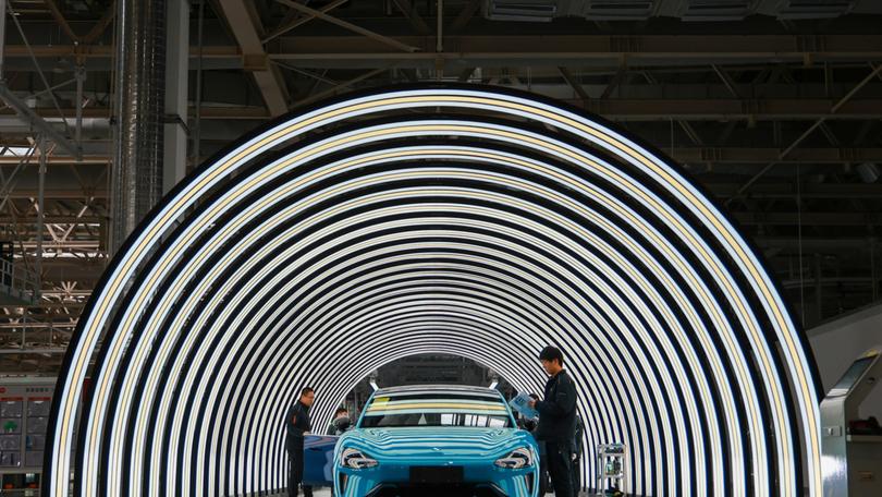 Employees work on the production line of electric vehicles at Xiaomi's Electric Vehicle Factory in Beijing.