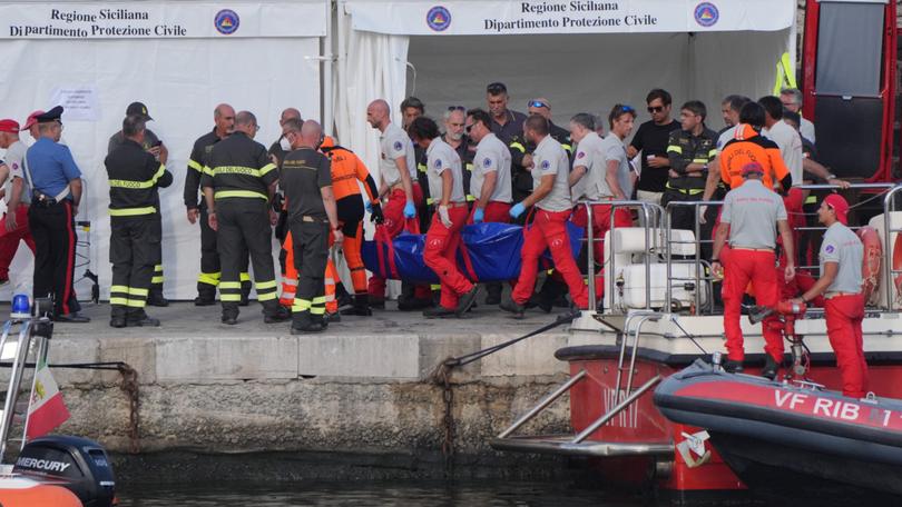 A body bag is brought ashore at the harbour in Porticello by rescue workers involved in search efforts after the luxury yacht Bayesian sank on Monday.