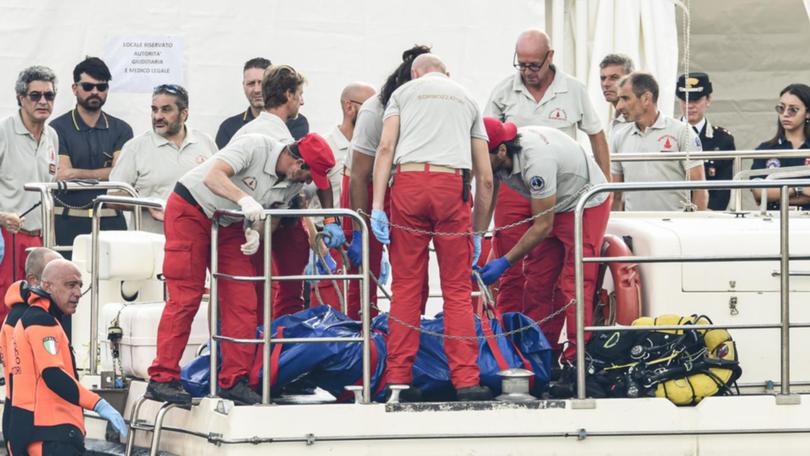 Italian divers bring a body bag from the sunken yacht off Sicily