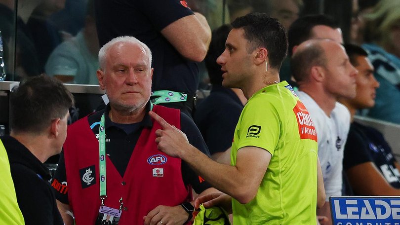 AFL goal umpire Steven Piperno was treated by medical officers after being hit by a bottle. (Morgan Hancock/AAP PHOTOS)