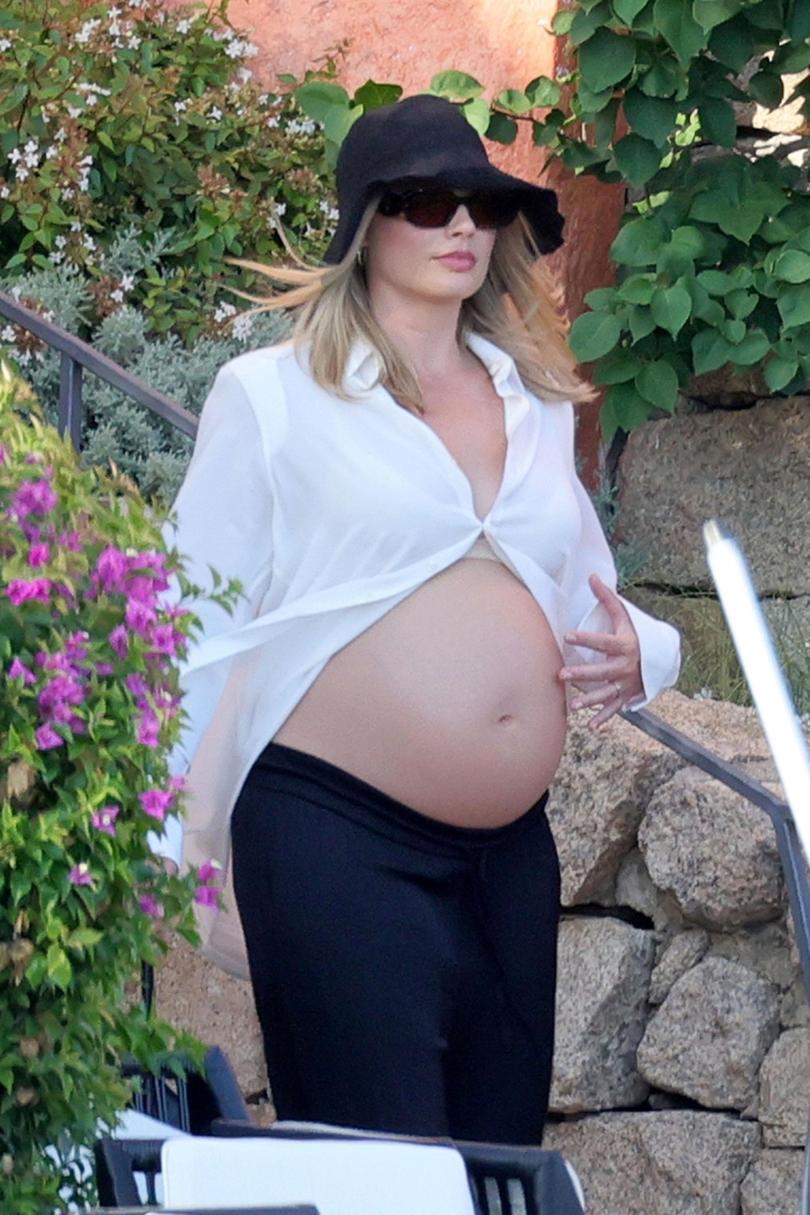 Margot Robbie has been spotted looking radiant as she showed off her blossoming baby bump while on holiday in Italy with her husband Tom Ackerley. 
