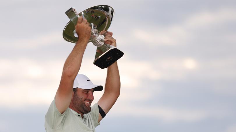 Scottie Scheffler celebrates with the FedExCup Trophy.