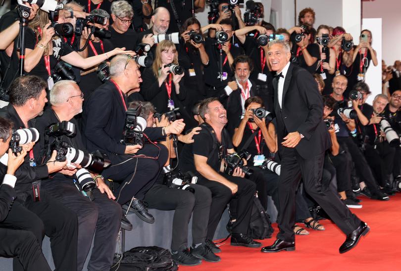 VENICE, ITALY - SEPTEMBER 01: George Clooney interacts with photographers during the "Wolfs" red carpet during the 81st Venice International Film Festival on September 01, 2024 in Venice, Italy. (Photo by Pascal Le Segretain/Getty Images)