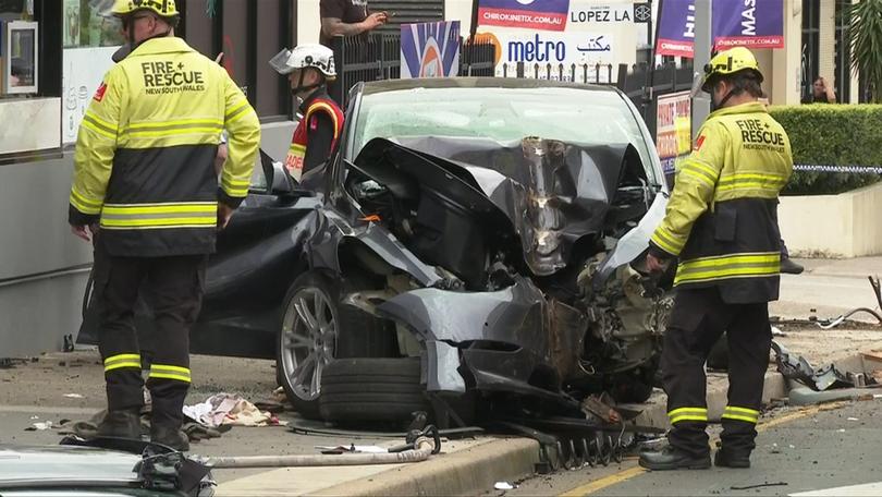 A Tesla crashed into a power pole in Bankstown, sending the pole toppling onto another car.