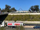 A convoy of trucks rolls past Parliament House ahead of the National Farmer Rally in Canberra. 