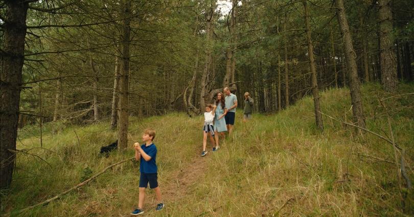 The Wales family skipping through the forest for a game of cricket.