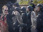 A protester gestures towards police officers during a violent anti-war rally. 