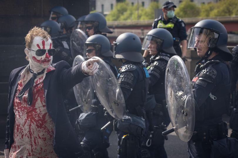 A protester gestures towards police officers during a violent anti-war rally. 