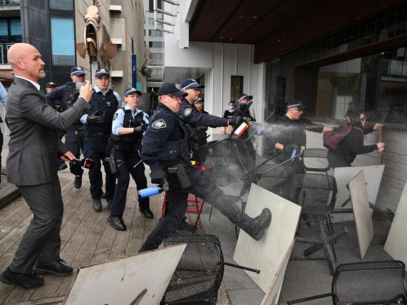 Police deploy pepper spray as they confront anti-war protesters.