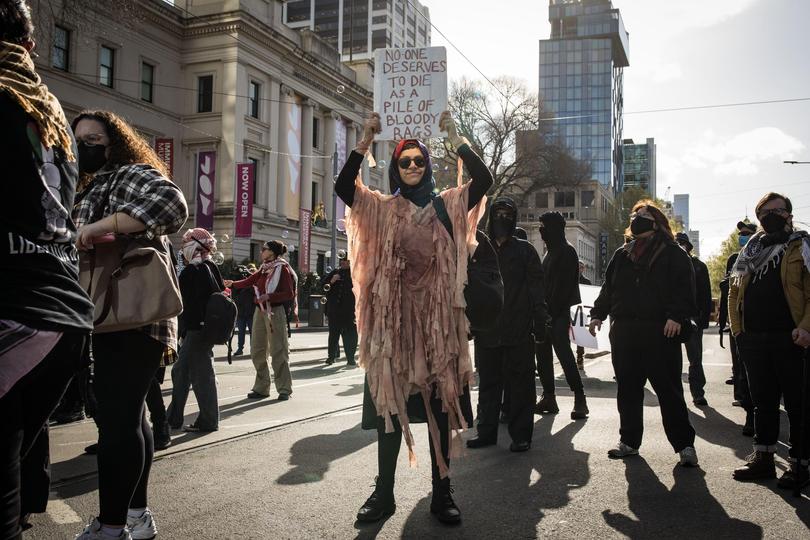 A protester is seen holding a sign during anti-war protesters in Melbourne.