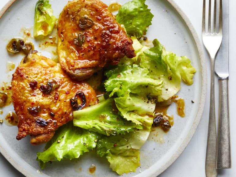 Skillet hot honey chicken with hearty greens offers supremely crisp, juicy chicken thighs and hot honey schmaltz, which serves as a warm vinaigrette for sturdy greens. Food Stylist: Simon Andrews. 