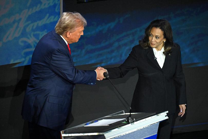 US Vice President and Democratic presidential candidate Kamala Harris (R) shakes hands with former US President and Republican presidential candidate Donald Trump.