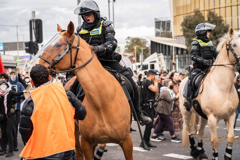 A police horse runs into a protester as the officer tells him to "move!" during the rally. A mass disruption by pro-Palestine and anti-war protesters took place in Melbourne's CBD. In response to the opening of 'Land Forces' a weapons expo. Around 12,000 protesters showed up to the disruption. Police used force, tear gas, rubber bullets, and pepper spray in an effort to control the crowd, The protesters threw water and bottles, rotten fruit, chairs, and more at the police. The protesters created dumpster fires in an effort to block the police. it is reported that at least 24 police officers needed medical attention, and at least 39 arrests were made. (Photo by Gemma Hubeek / SOPA Images/Sipa USA)