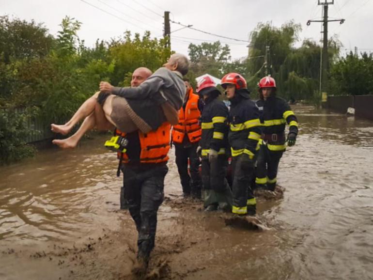 Torrential rain in Romania has killed at least four people and left scores stranded by flooding. (AP PHOTO)