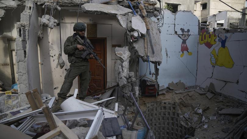 An Israeli soldier stands at the entrance of a tunnel where the military says six Israeli hostages were recently killed by Hamas militants in the southern Gaza Strip.