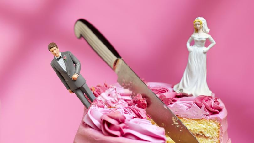 knife cutting between bride and groom figurines, relationship breakup