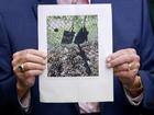 Palm Beach County Sheriff Ric Bradshaw holds a photograph of the rifle and other items found near where a suspect in the attempted assassination attempt was found.