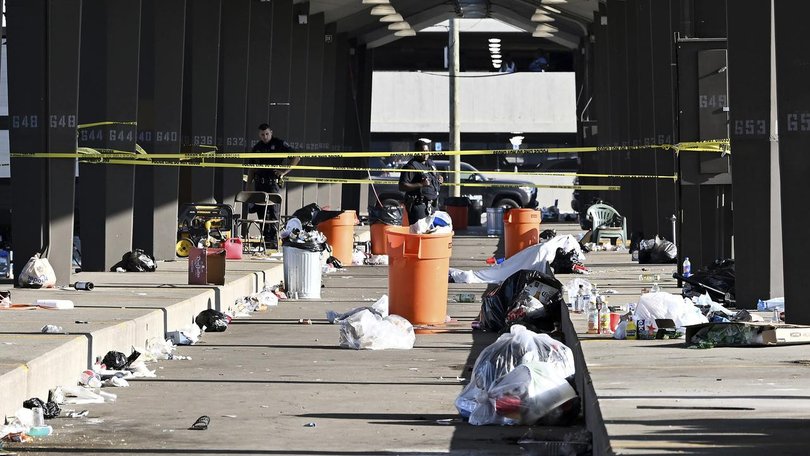 Officers stand behind police tape at the scene of the tailgating spot shooting in Detroit.