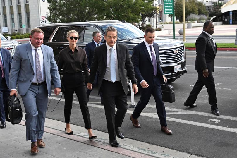 Lachlan Murdoch, centre, and his wife Sarah arrive at court.