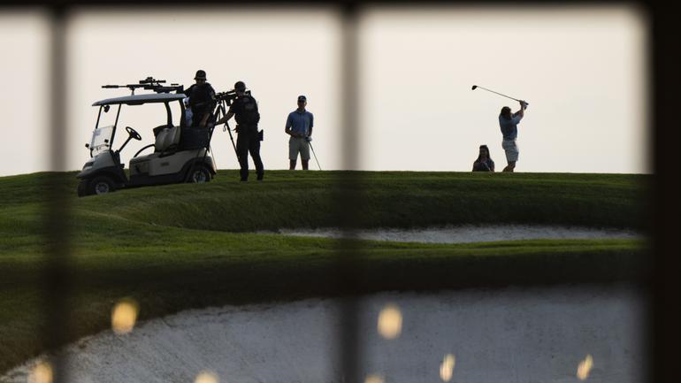 A sniper team is set up next to golfers as Trump speaks during an event at Trump National Golf Club.