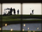 A sniper team is set up next to golfers as Trump speaks during an event at Trump National Golf Club.