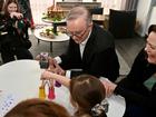 Prime Minister Anthony Albanese shows a photo of his dog, Toto, to children at a Dayton childcare centre during his trip to Perth.