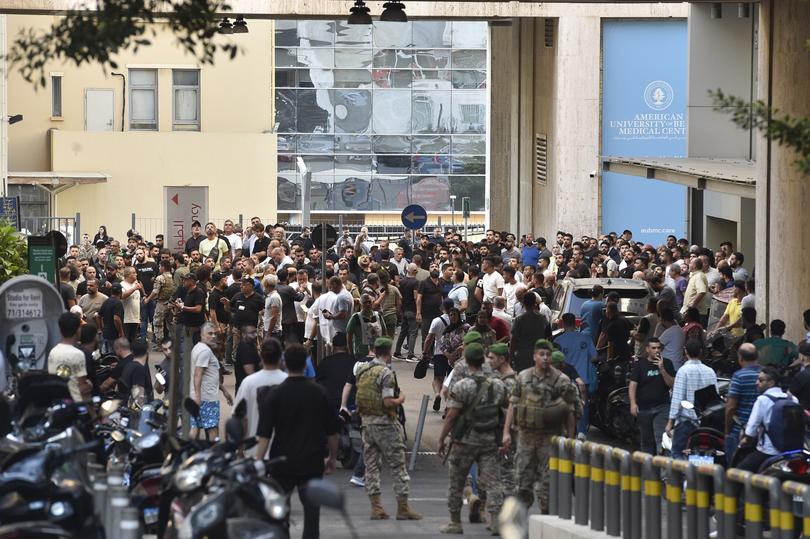 Lebanese soldiers and Hezbollah members gather outside the American University of Beirut Medical Center (AUBMC) after an incident involving Hezbollah members' wireless devices in Beirut, Lebanon.