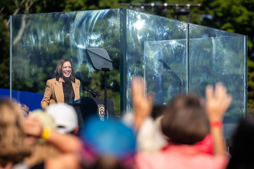 Vice President Kamala Harris laughs from behind a bulletproof enclosure during a campaign rally in North Hampton, N.H. 