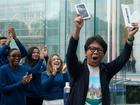 Apple employees applaud as a customer celebrates their purchase of Apple's iPhone 16 launch in New York.